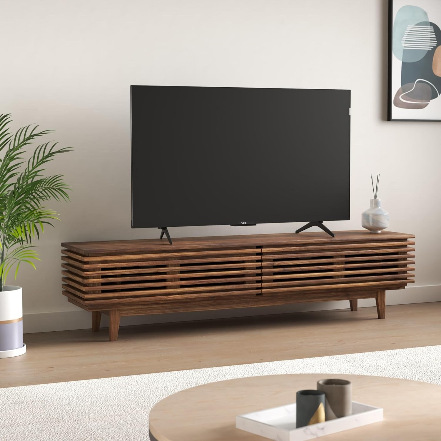 Tanish 55-Inch QLED TV mounted on wall in modern living room setup with edge-to-edge screen